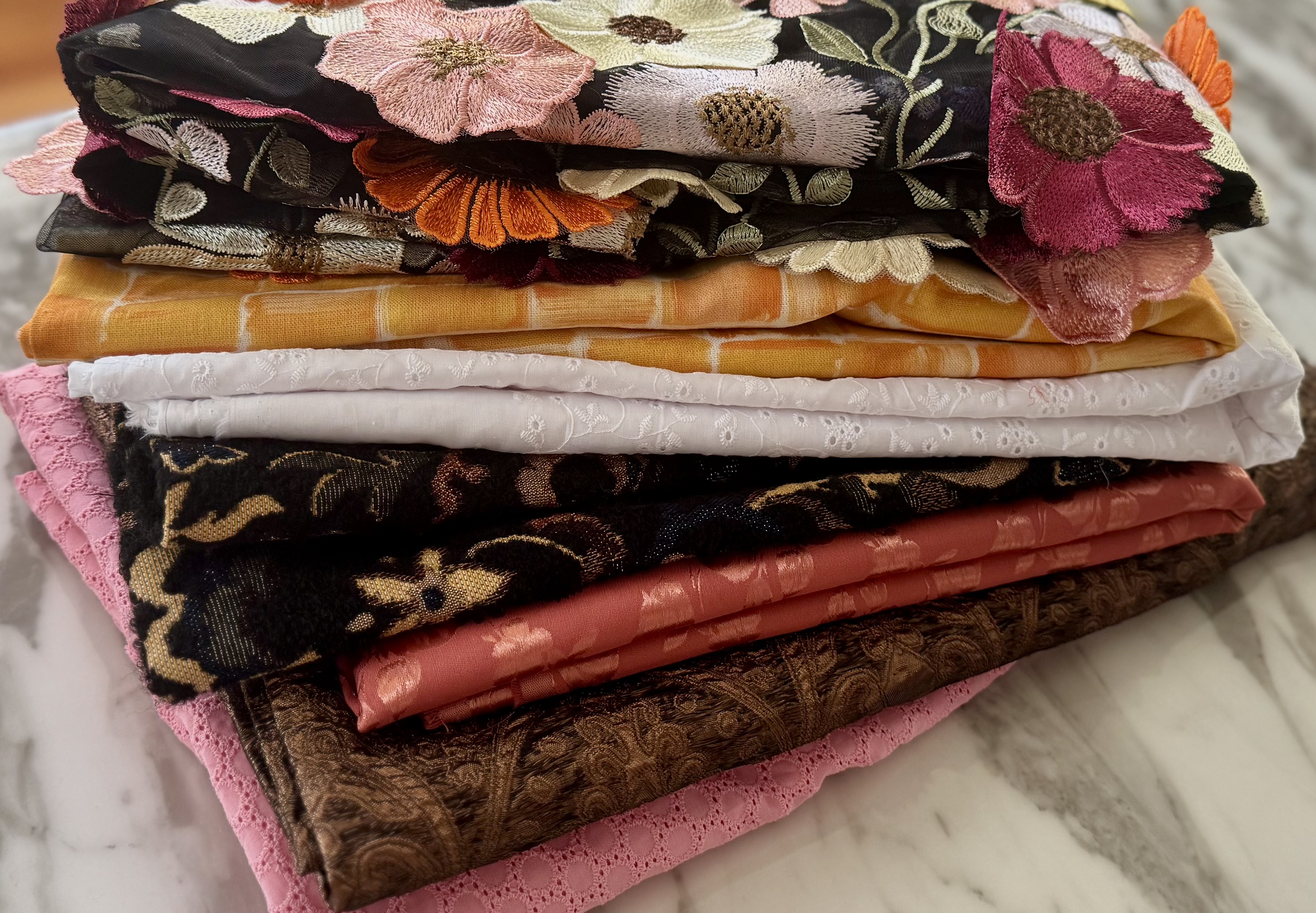 Stack of folded fabrics in warm neutral tones